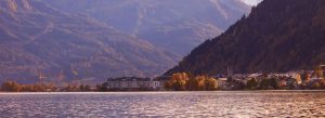 Panoramic view of Zell am See lakeside town in Austria with mountains autumn colors and shimmering lake waters