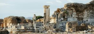 Ancient ruins of Ephesus in Selçuk, Turkey featuring Roman stone columns, arches, and historic structures under a clear sky.