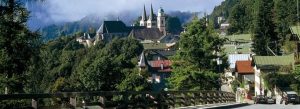 Scenic view of Berchtesgaden town in Germany surrounded by lush forests and the Bavarian Alps under misty mountain skies.