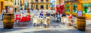 Outdoor cafés and historic streets in the charming town center of Pamplona, Spain, with people enjoying the lively atmosphere.