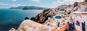 Whitewashed cliffside village of Oia with blue-domed churches overlooking the Aegean Sea in Santorini, Greece